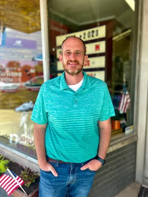 Jim, owner of Eckstein Shoe Store and Repair, standing outside the shop