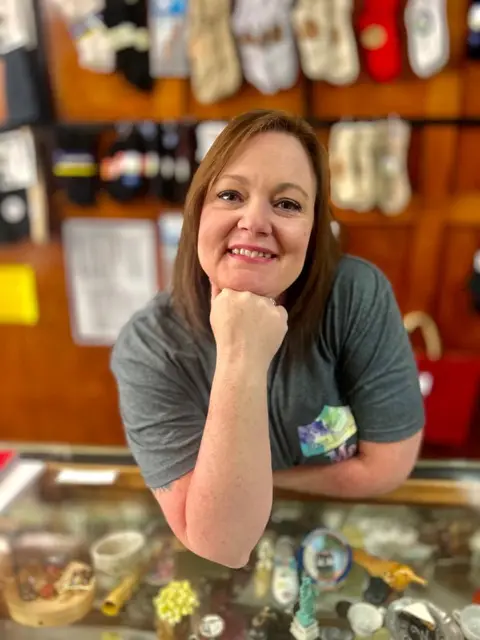 Mary smiling at the counter inside Eckstein Shoe Store and Repair