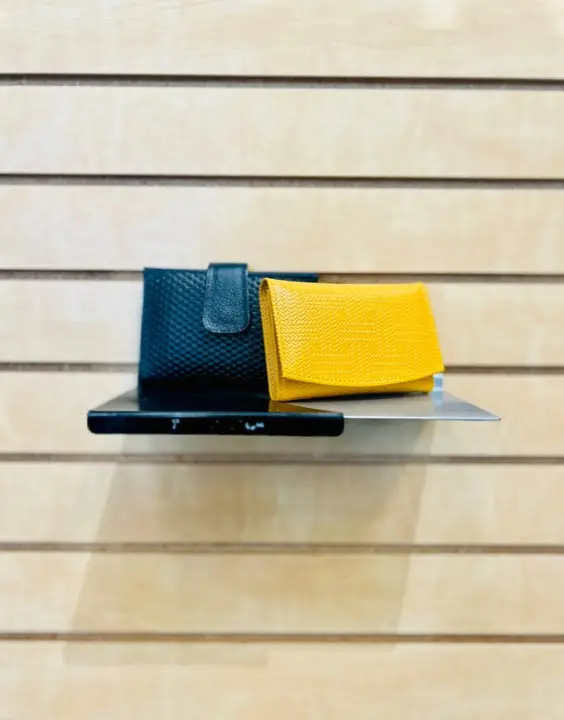 Yellow and black leather wallets on a shelf